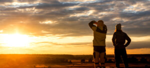 A young girl and her young man see off the setting sun. They look up at the sky. They walk after they get out of quarantine. A couple of young people together went on a small trip.